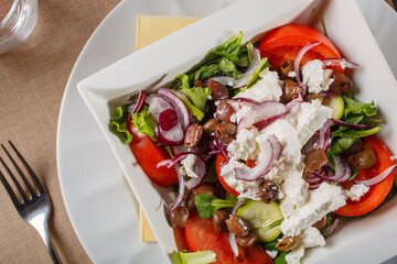 Insalata greca con feta, pomodori, cipolle rosse, cetrioli, pomodori e lattuga servita in un ristorante elegante