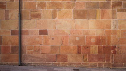 Fachada de palacio antiguo de bloques de piedra anaranjada 