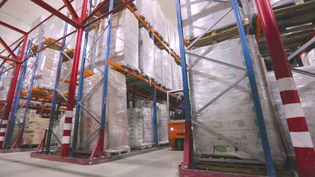 Large warehouse in the factory. The forklift is driving through the warehouse of the factory. Modern warehouse.Warehouse work