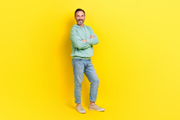 Fototapeta na wymiar Full length photo of good looking man wear fashionable clothes arm crossed stand empty space ad banner isolated on yellow color background