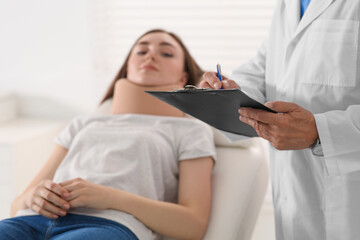 Orthopedist examining patient with injured neck in clinic, closeup - Powered by Adobe