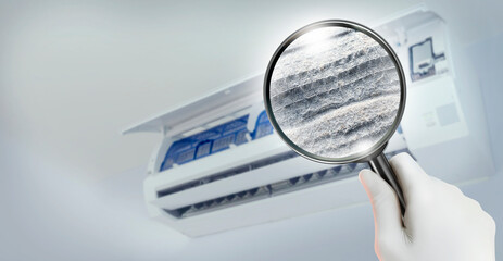 Dust and dirt inside of an air conditioner filter through a magnifying glass.health care and...