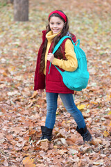 Happy schoolgirl back to school in autumn. Teen girl carrying school bag on September 1