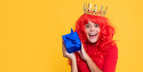 amazed child in queen crown with present box on yellow background