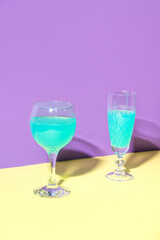 Two glasses of wine. The concept design of the celebration. Minimalistic trendy style. Yellow, Turquoise, Purple color.