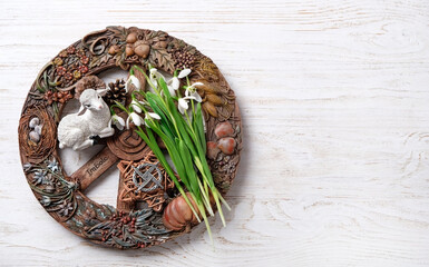 Wiccan altar for Imbolc sabbat. pagan festive ritual. Brigid's cross amulet, wheel of the year, snowdrop flowers, toy lamb on wooden table. Imbolc holiday, spring equinox. top view. copy space - obrazy, fototapety, plakaty