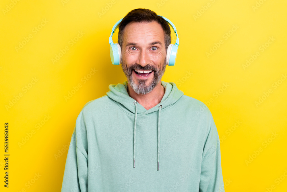 Poster photo of cheerful guy dressed mint sweatshirt headphones impressed staring at camera open mouth isol