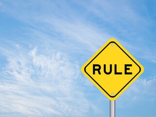 Yellow transportation sign with word rule on blue color sky background