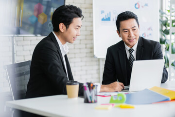 Professional Asian business adviser meeting to analyze and discuss the strategy of financial support of a tech company. Partnership start-up consultant, Indoor business client consultation concept.