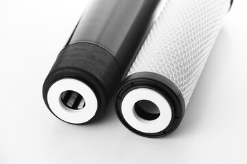 two filter cartridges for house water filtration system isolated. Granular and briquettes carbon...