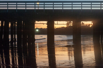 The setting sun is being reflected in the water behind the Santa Cruz Wharf.