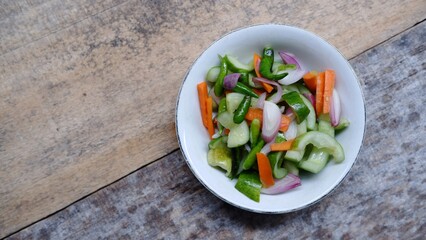 Acar timun, Indonesian traditional pickle cucumber. Side Dish for Chicken, Meat, or Martabak Dish. Diced Carrot and Cucumber with Green Chilli and Shallot, Mix with Vinegar, Sugar, Salt. On White Bowl