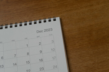 December 2023 calendar page on wood background. Calendar background for reminder, business planning, appointment meeting and event.