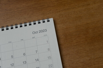 October 2023 calendar page on wood background. Calendar background for reminder, business planning, appointment meeting and event.