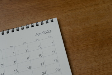 June 2023 calendar page on wood background. Calendar background for reminder, business planning, appointment meeting and event.