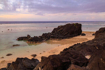 The Black Rock, a distinctive basalt formation on a beach on Rarotonga, Cook Islands, at sunset