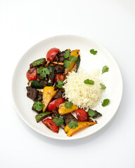 Meat with vegetables and rice. Dinner. Portion of food on white plate. Isolate on white background. View from above. Copy space.