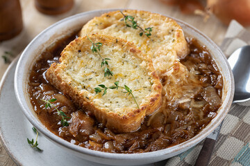 French onion soup with toasted cheese baguette garnished with thyme