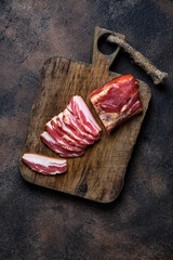 smoked bacon on a wooden board with several cut pieces