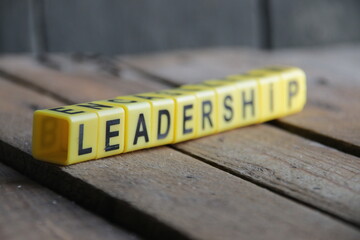 Leadership. The inscription from the cubes on a wooden background.