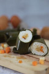 a close up of lontong. Traditional food from Indonesia originating from rice filled with vegetables or meat and wrapped in banana leaves. Indonesian traditional food photo concept.
