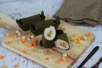 a close up of lontong. Traditional food from Indonesia originating from rice filled with vegetables or meat and wrapped in banana leaves. Indonesian traditional food photo concept.