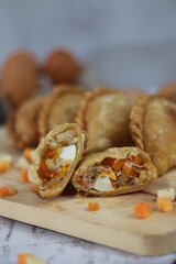 a close up of pastel cake which is a traditional indonesian food. filled with chicken, vegetables, or boiled eggs and served with sauce or chili. Indonesian traditional food photo concept.