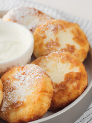 Cottage cheese pancakes, syrniki, on a light background. Copy space.