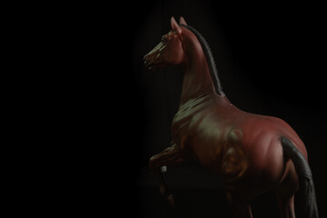 Fototapeta na wymiar Black toy horse isolated on black background