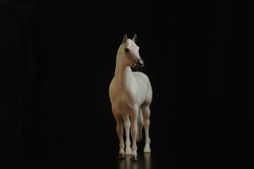 Black toy horse isolated on black background