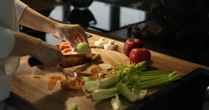Cropped woman hands skillfully chopping fresh onion in wooden kitchen corner. Seasonal restaurant menu, new cafe recipe