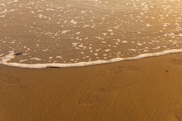 Sea foam created by waves on the beach