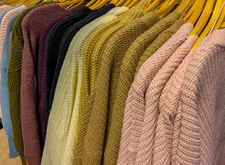 Strickjacke und Strick Pullover auf Kleiderbügel zum Winterschlussverkauf