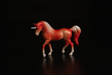 Black toy horse isolated on black background