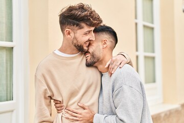 Young couple smiling confident hugging each other at street