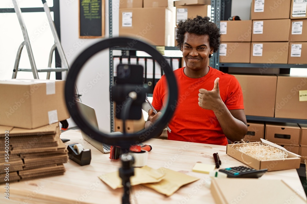 Canvas Prints African man working at small business ecommerce doing video tutorial smiling happy and positive, thumb up doing excellent and approval sign