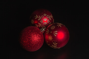 Red Christmas ball on a Christmas tree with a garland on the black background