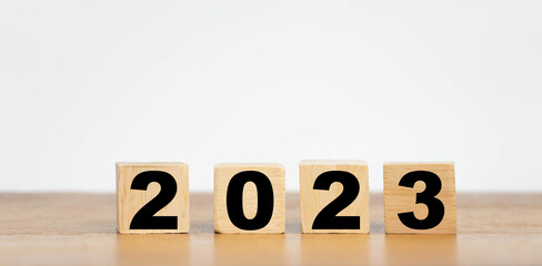 Wooden Cube turns from 2022 to 2023 on wooden table,Happy new 2023 year, countdown and New Year holiday concepts.