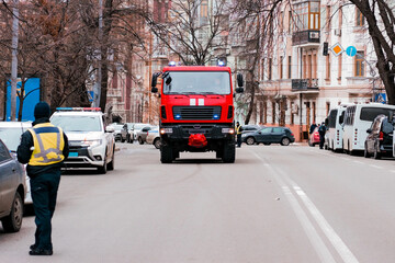 Fototapeta premium Modern fire-fighting truck moving toward the city's road. City. Emergency. Engine. Fire. Service. Shiny. Urgency. Alarm. Department. Firetruck. Health. Siren
