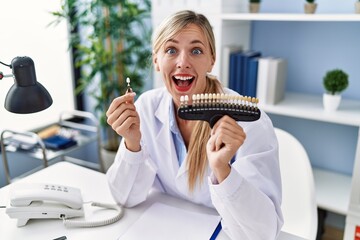 Beautiful dentist woman comparing teeth whitening celebrating crazy and amazed for success with...