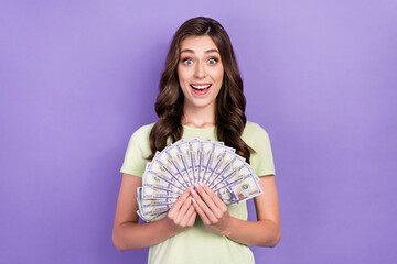 Photo of rich business owner company young woman wear white t-shirt hold much money excited big sales profit isolated on purple color background