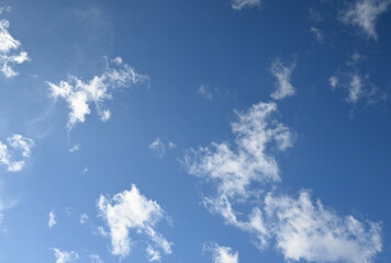 Fototapeta na wymiar Fondo natural con detalle de varias nubes de tonos blancos y cielo azul con degradado de luz