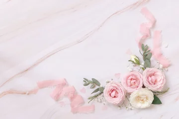 Fotobehang Pink and cream roses and silk ribbons on white marble top view, Romantic wedding background © katrinshine