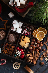 On the table there is a box with nine compartments in which nuts, cookies and spices are poured
