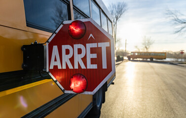 Gros plan d'un signal d'arrêt d'autobus scolaire à contre-jour