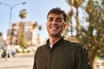 Young hispanic man smiling confident standing at park