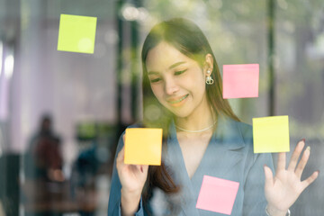 Young confident Businesswoman planning with adhesive notes in creative office.