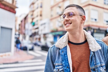 Young hispanic man smiling confident looking to the side at street