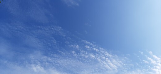 Naklejka na ściany i meble Blue sky on a shiny day with beautiful clouds