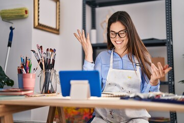 Young woman artist having video call drawing on notebook at art studio